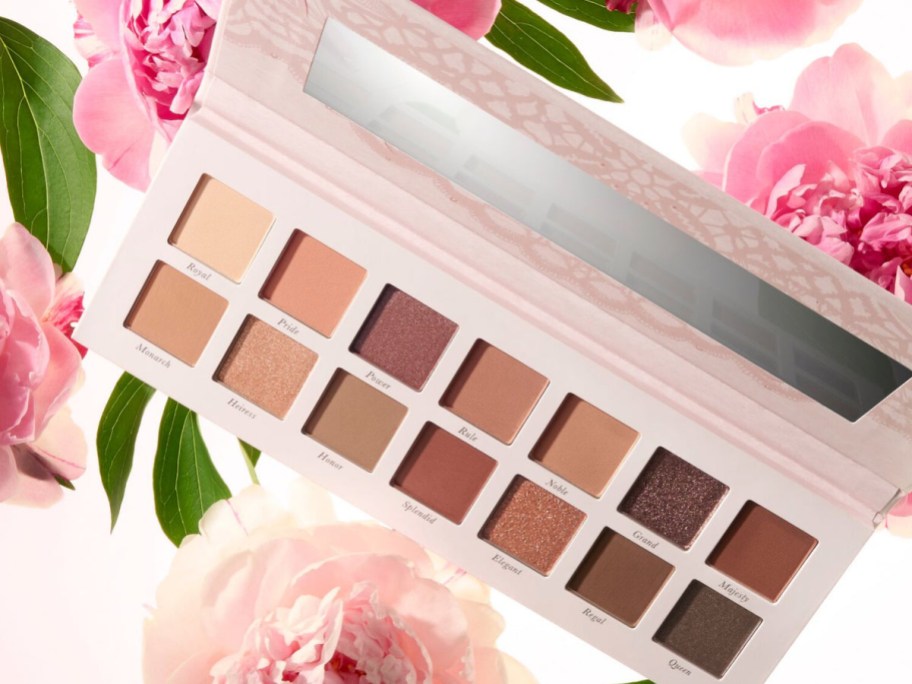 Laura Gellar brown eyeshadow in a pink case with flowers in the background