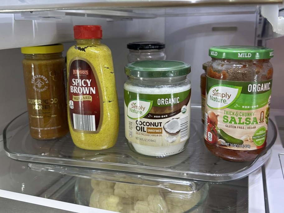 condiments in fridge on a clear lazy susan turntable
