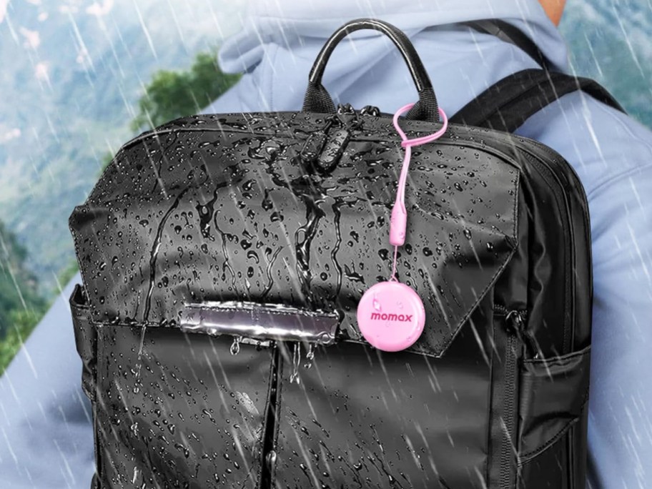 momax tracker tag hanging on black backpack in rain