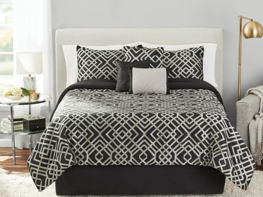 a black and gold comforter set on a queen size bed