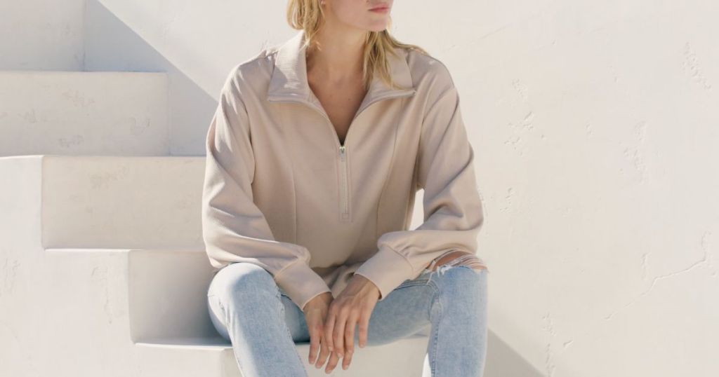 woman sitting on stairs wearing a Merokeety pullover