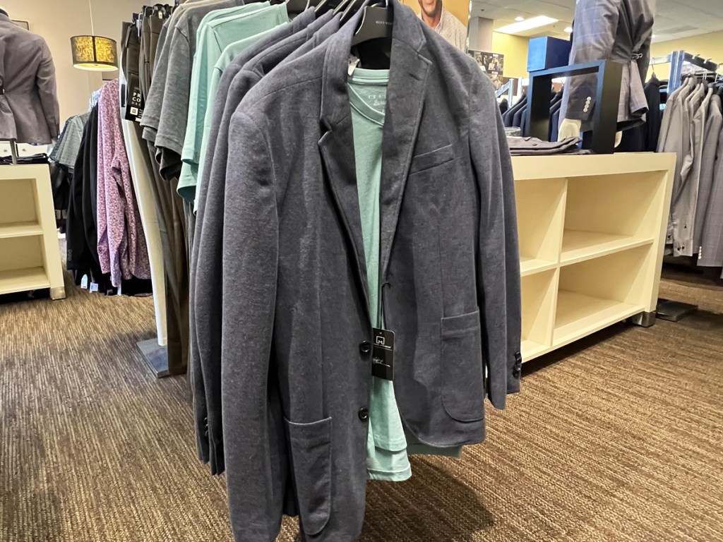 grey jacket over green tee on store display rack