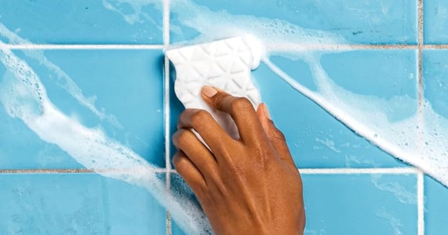 person using mr.clean magic eraser on tile