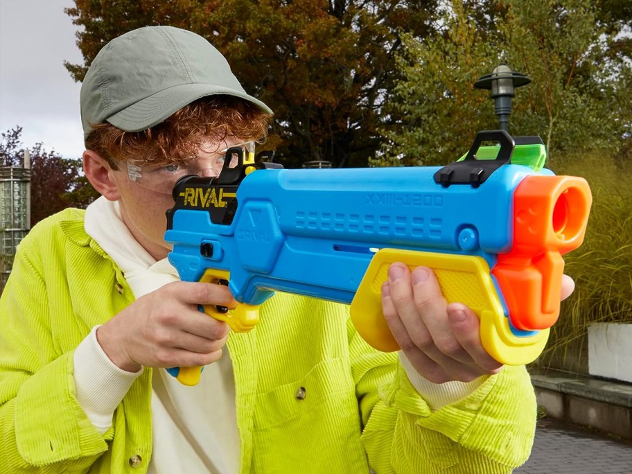 boy holding and aiming a blue nerf blaster