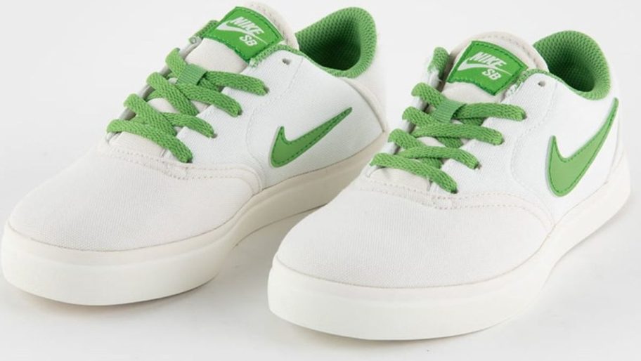 a pair of kids nike skate board shoes in withe and gree