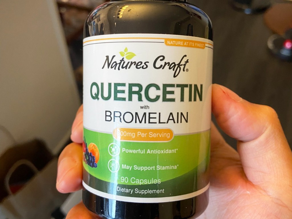 hand holding a bottle of Nature's Craft Quercetin capsules