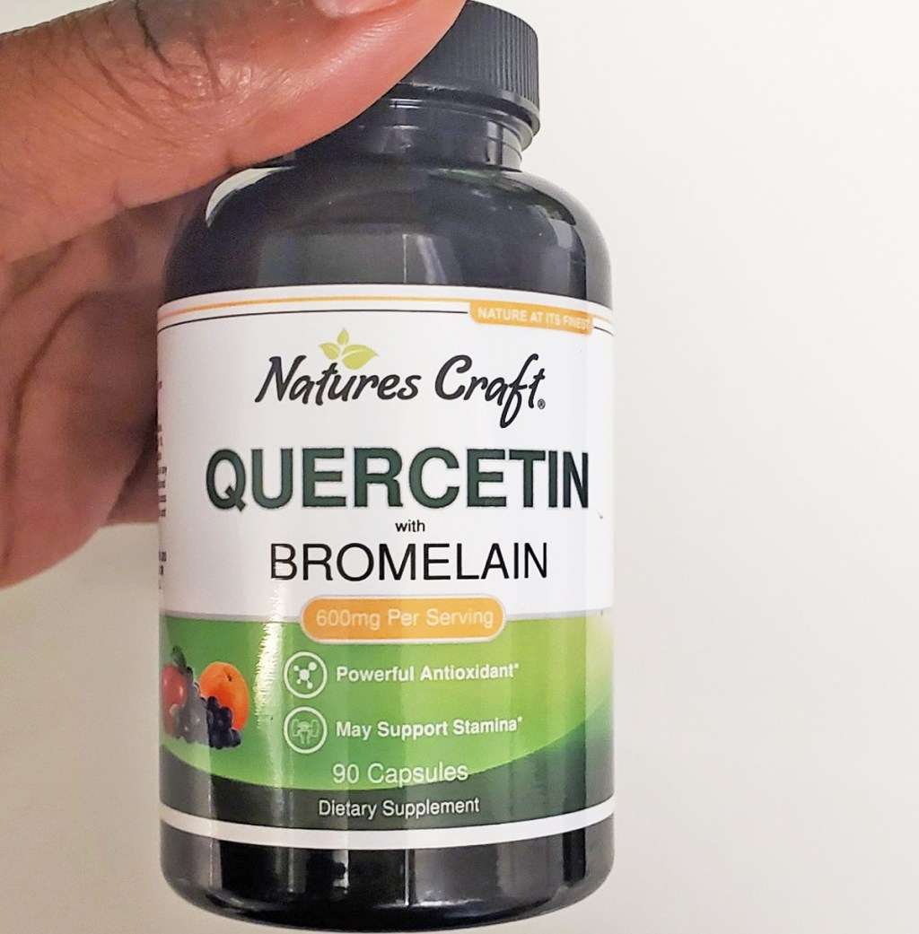 hand holding a bottle of Nature's Craft Quercetin capsules