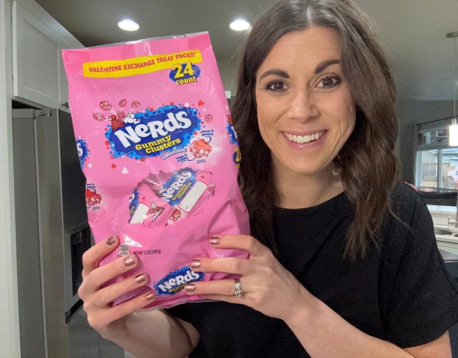 Woman holding up Nerds Gummy Cluster treat bags