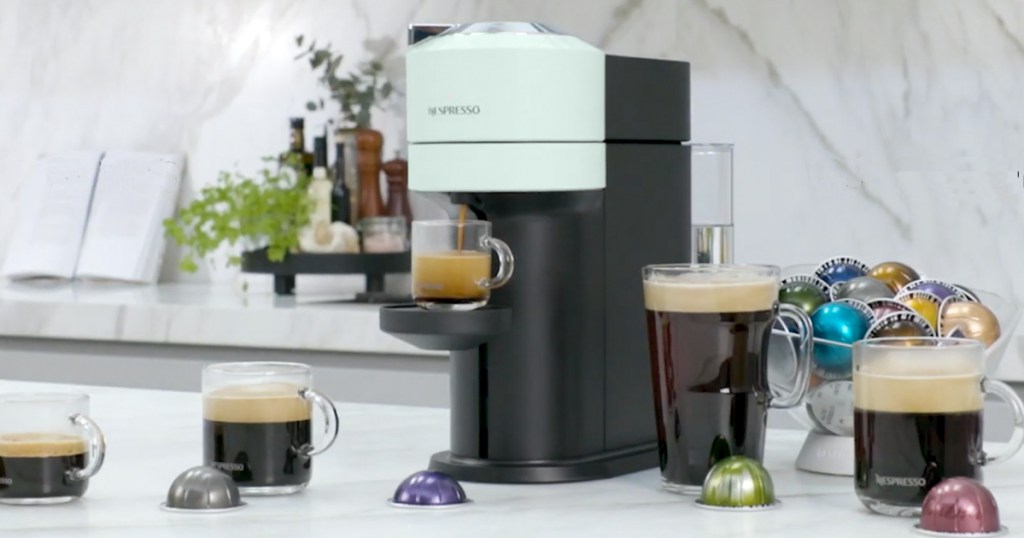 nespresso machine on kitchen counter with various cups of coffee and capsules in front of it
