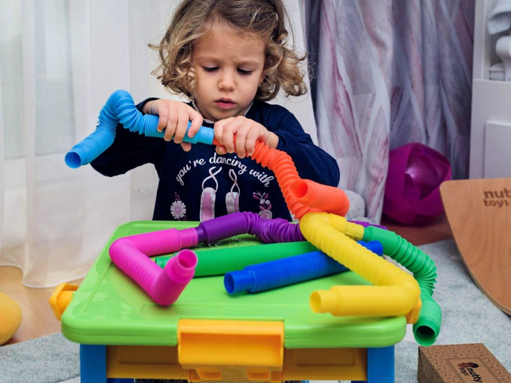 toddler playing with Nutty Toys Pop Tubes