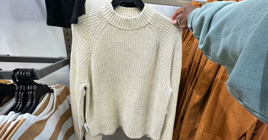 A white women's old navy sweater on a hanger