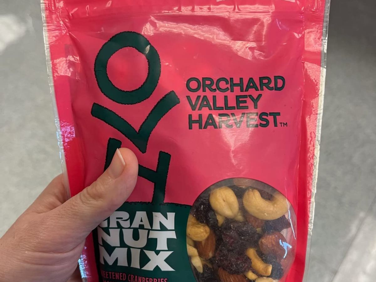 person holding bag of orchard valley harvest nut mix