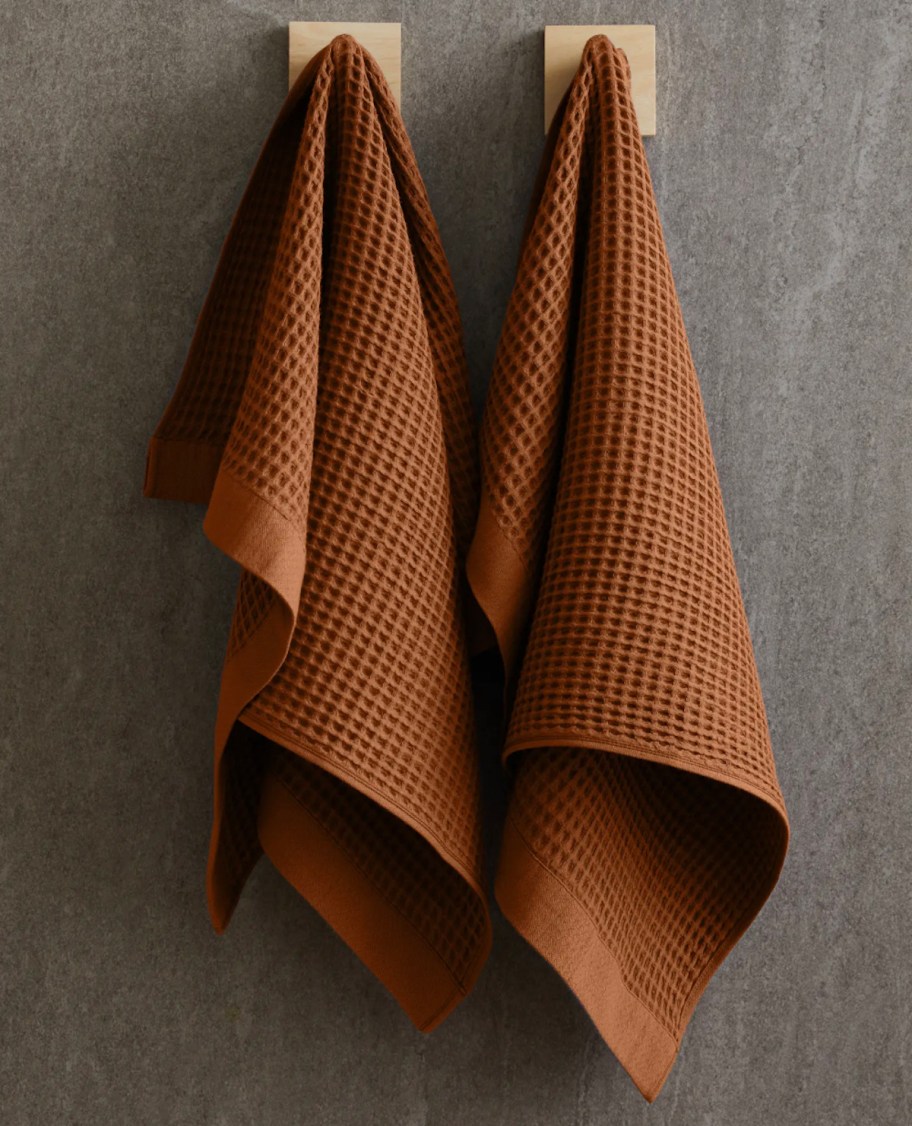 terracotta waffle blankets hanging on modern square hooks on dark gray wall