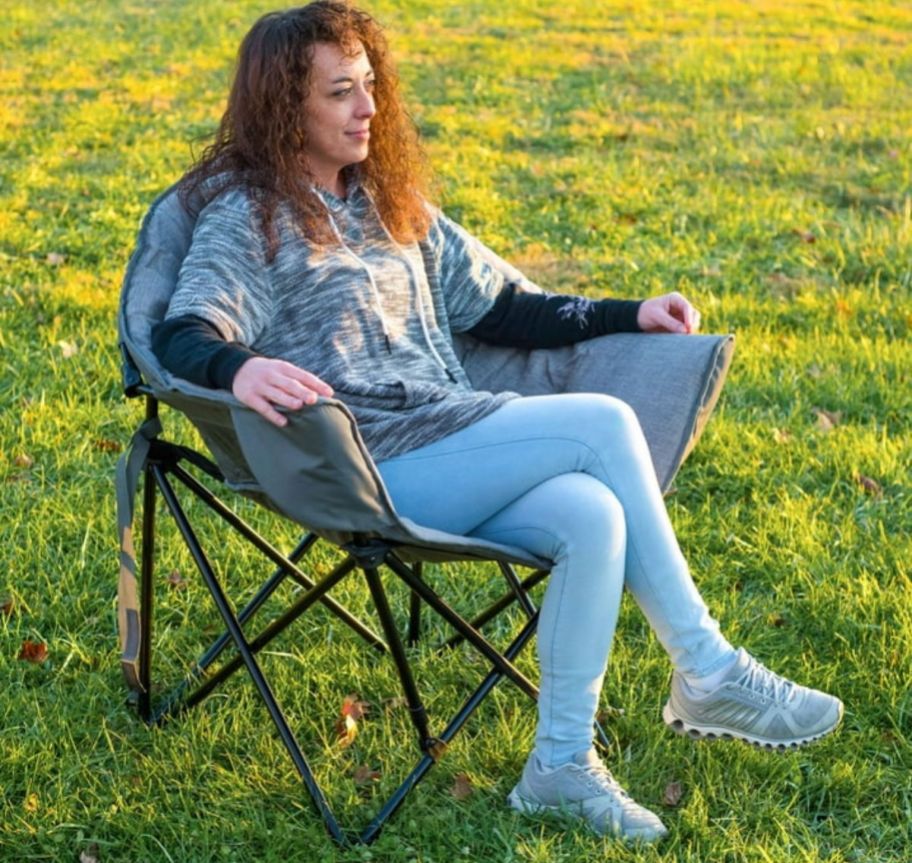 a woman sitting in a gray camping club chair