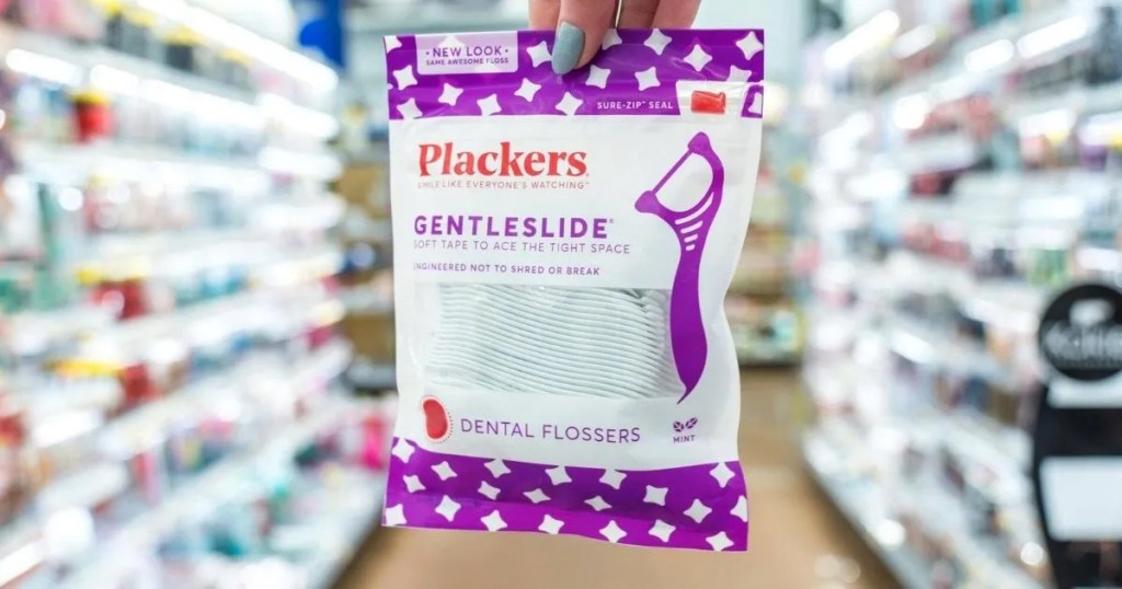 hand holding up a purple and white bag of Plackers Gentleslide Floss Picks