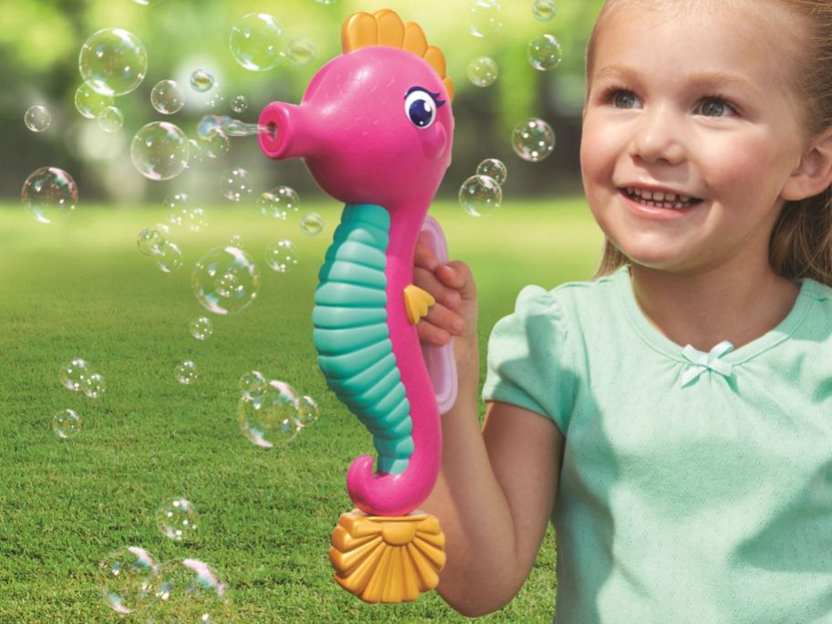 A little girl blowing bubbles with a Play Day Seahorse Bubble Blower 