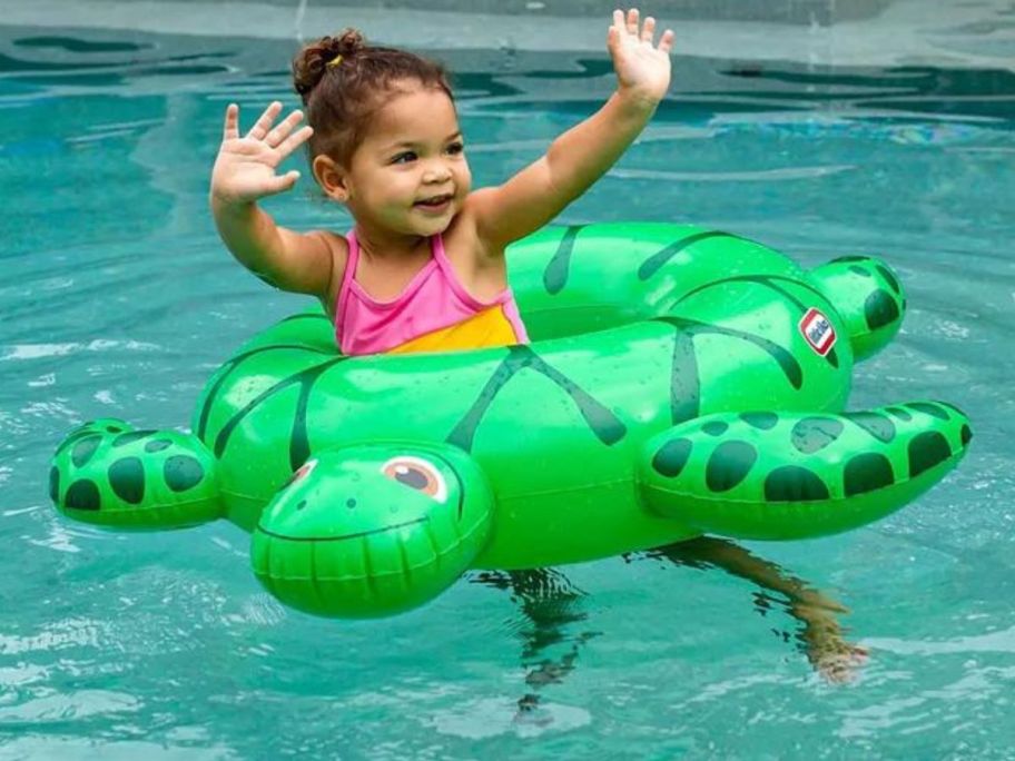 A child in a pool in a turtle float