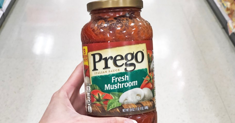 hand holding jar of Prego Pasta Sauce in Fresh Mushroom flavor
