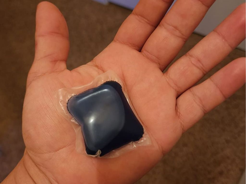 Hand holding a purex laundry detergent pac