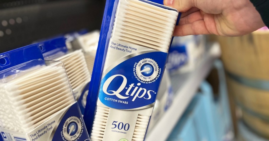 hand grabbing a 500-count pack of q-tips from store shelf