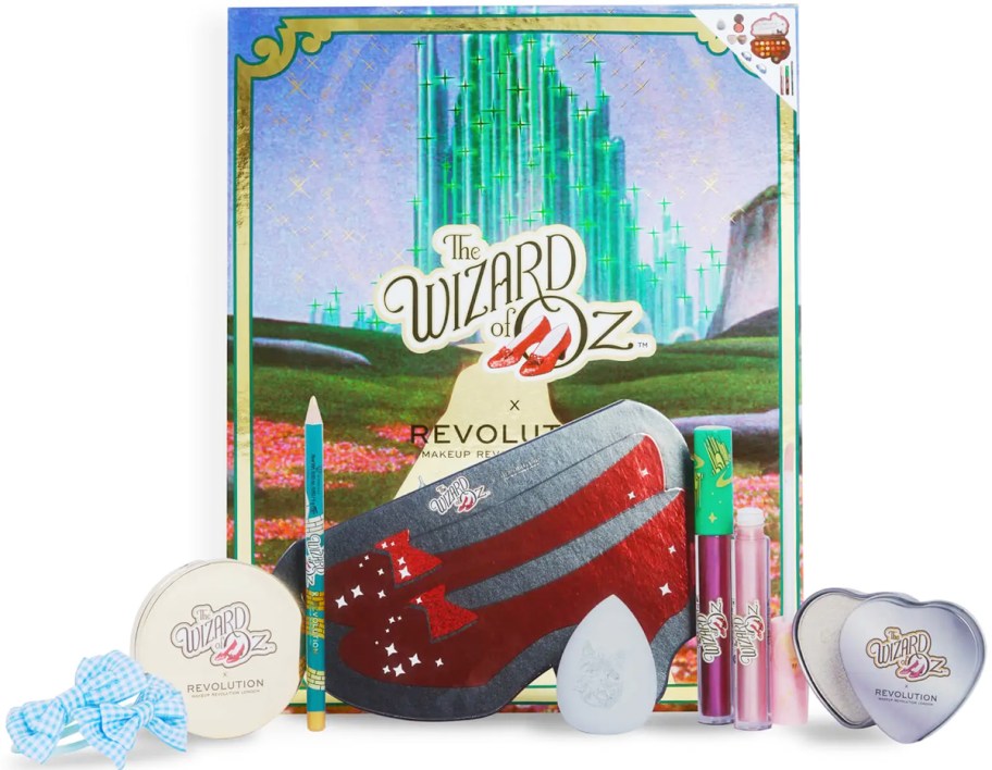 Wizard of Oz makeup set with eyeshadow palette, gold eyeliner pencil, two sparkling lip glosses, pink shimmering blusher, highlighter, grey blending sponge, and two hairbands