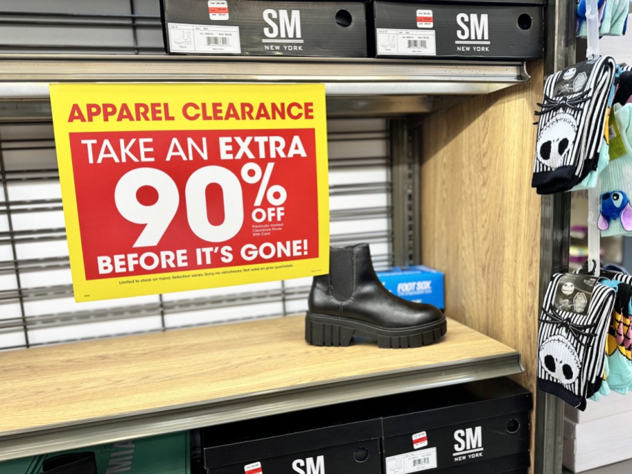 black boots on store display with yellow and red clearance sign