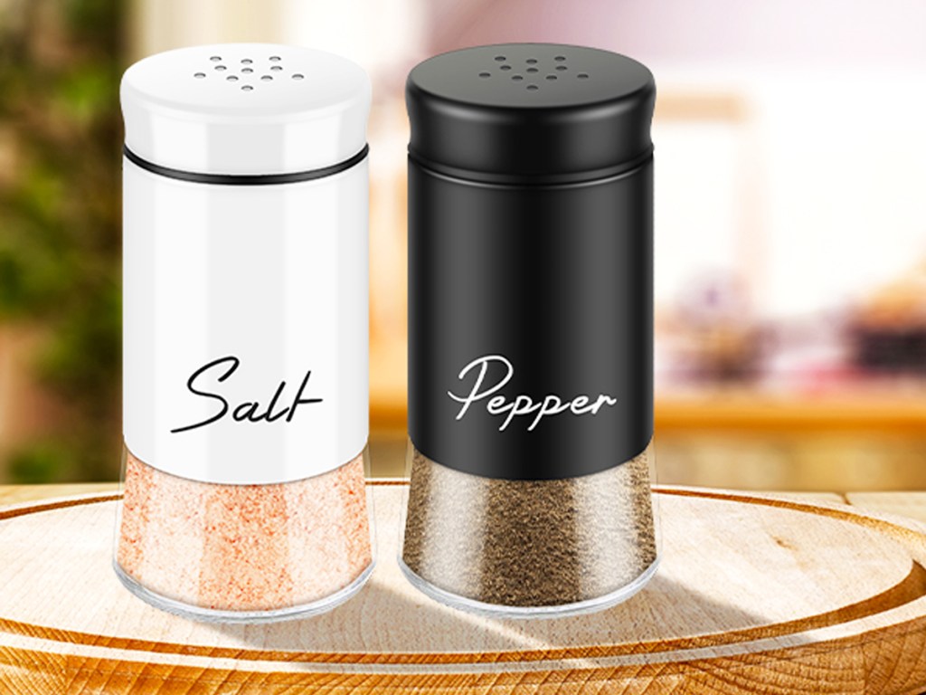 white and black salt and pepper shakers on round wood board