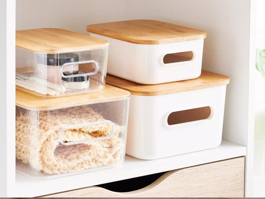 stacked plastic storage bins with bamboo lids on shelf
