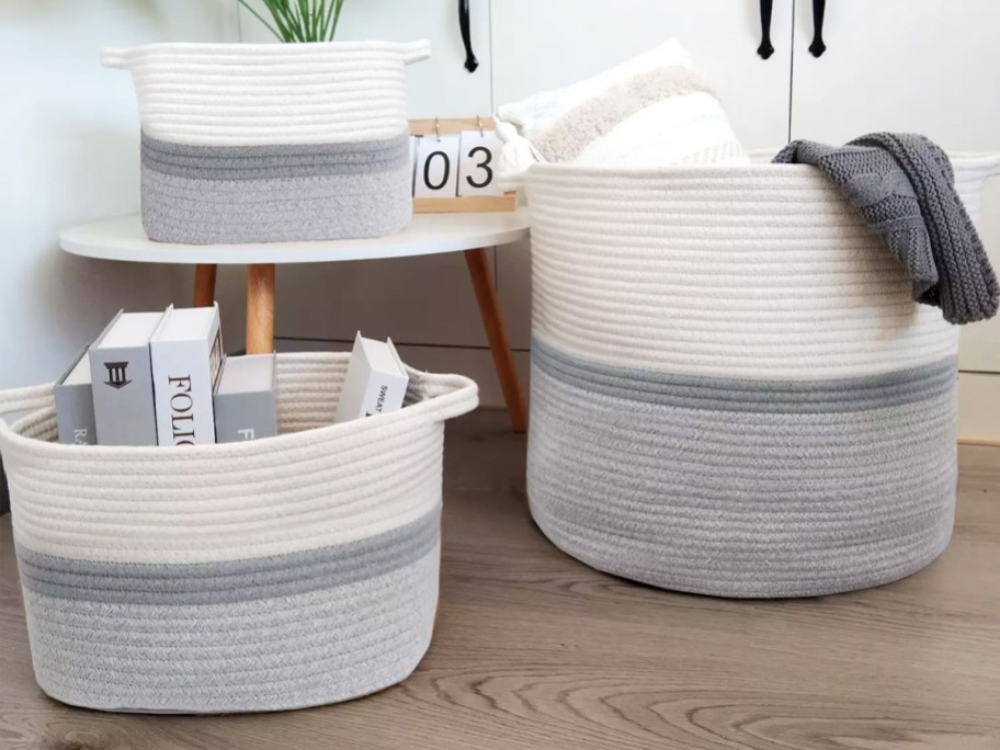 grey and white rope storage bins with blankets and books inside