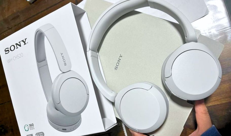 a pair of white wireless bluetooth headphones next the packaging