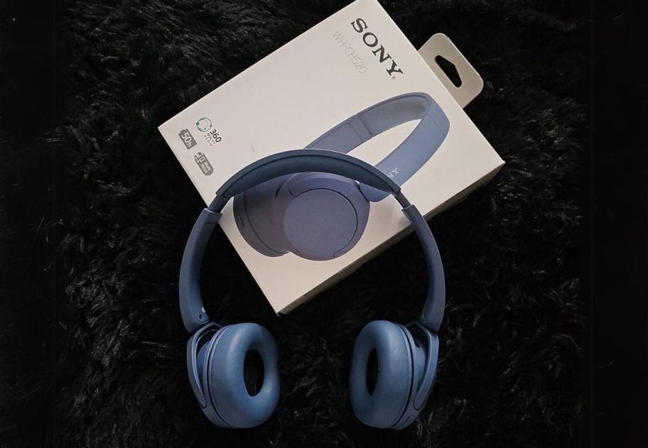 a pair of blue wireless bluetooth headphones shown with packaging