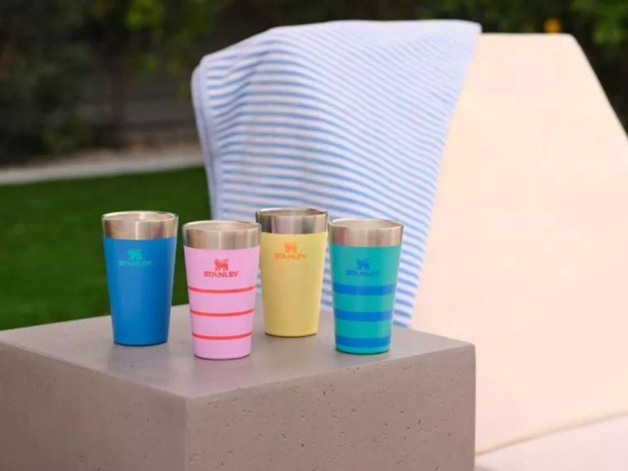 colorful Stanley tumblers on gray side table