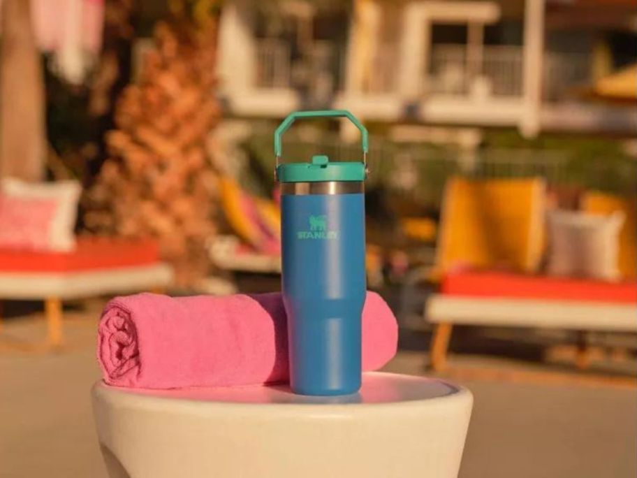 blue Stanley water bottle next to pink towel