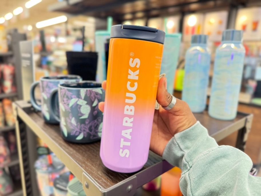 hand holding an orange and purple ombre Starbucks tumbler