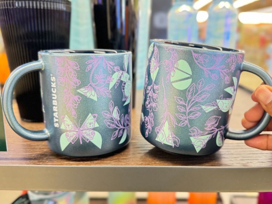 blue glittery Starbucks mugs with butterflies on them sitting on a shelf