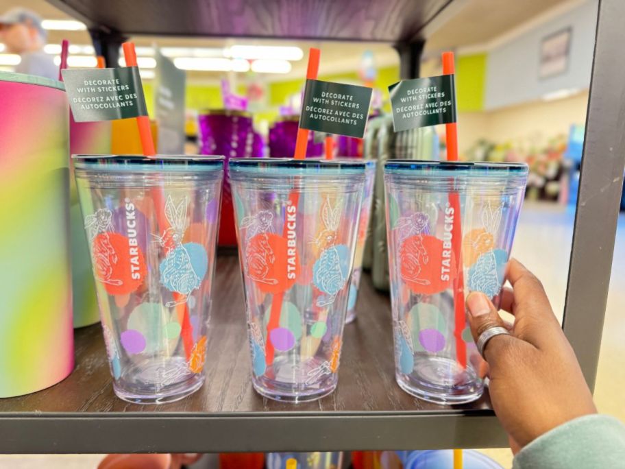 hand reaching for a Starbucks tumbler that has spring color dots and bunny rabbits