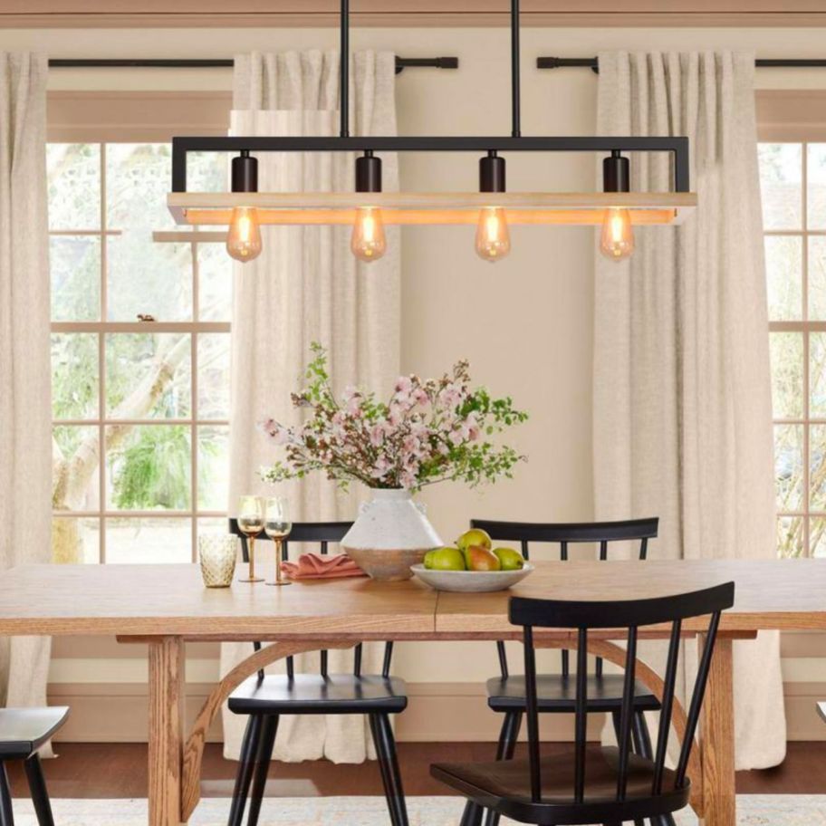 an industrial or farmhouse style metal rectangular 4 light chandelier hanging over a dining table