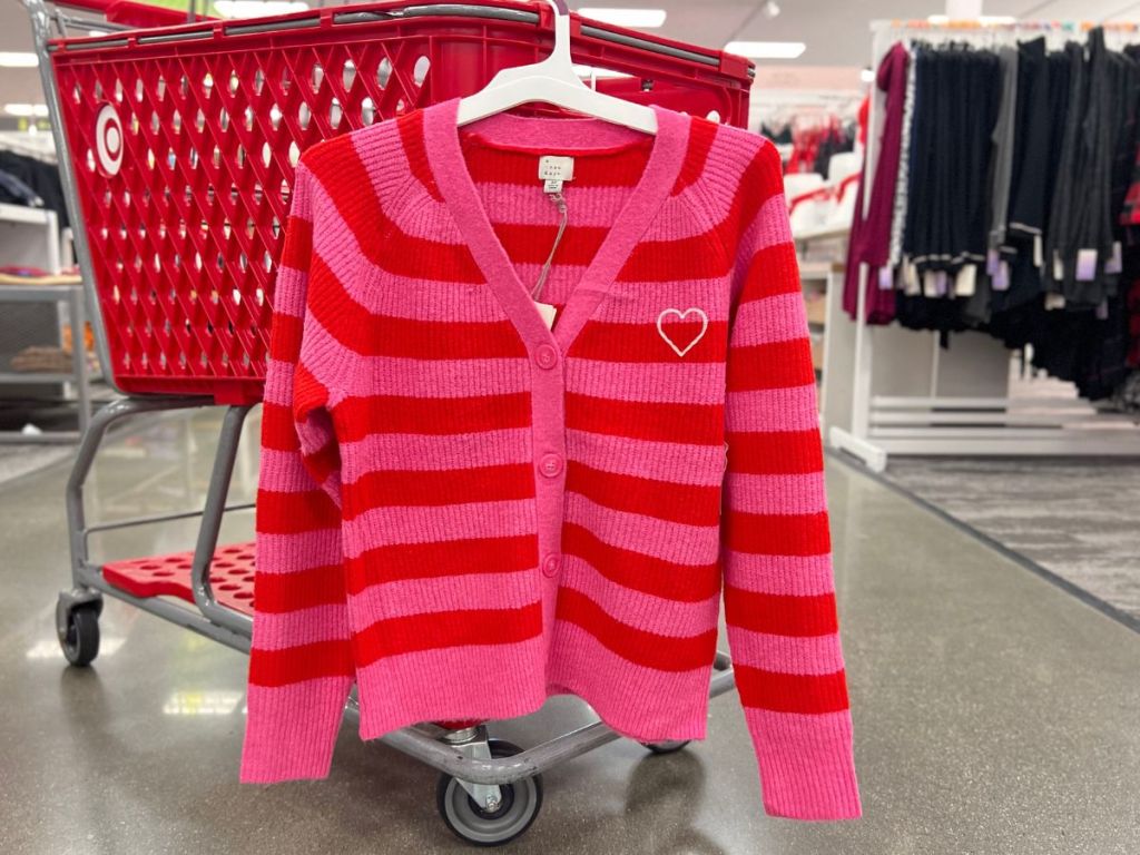women's Valentine's Day pink and red striped v-neck button down cardigan hanging on Target cart