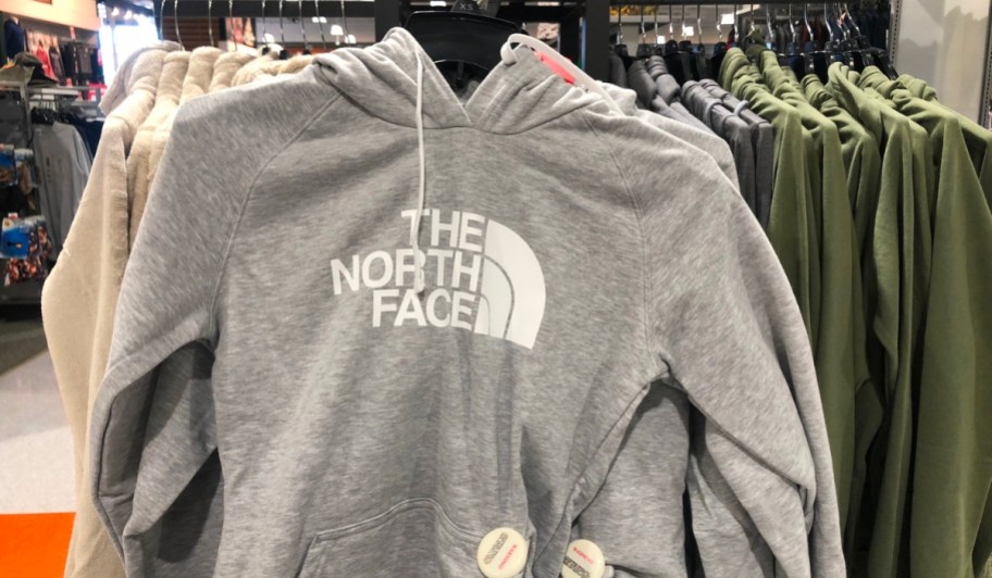 the north face hoodie in gray hanging in store