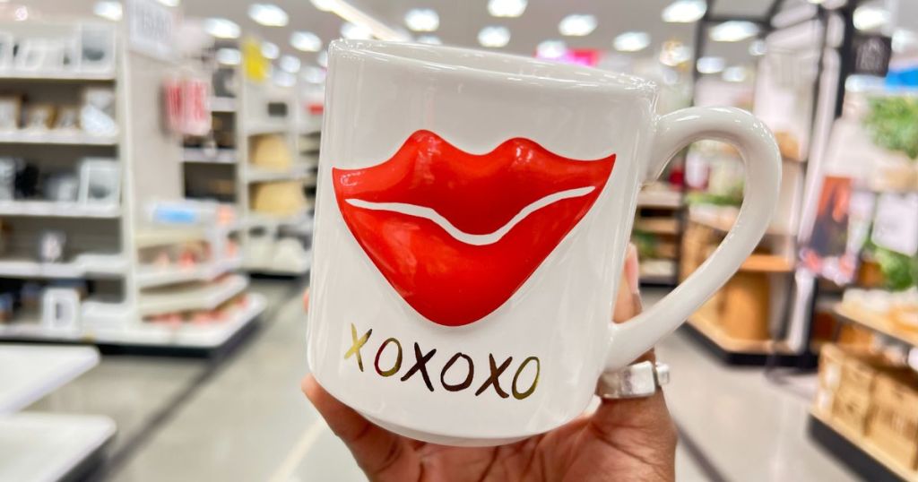 a womans hand displaying a Threshold Valentine's Day Figural Embossed Lip Mug 15oz on a store aisle