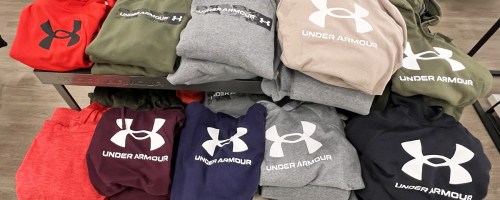 display table full of folded under armour hoodies