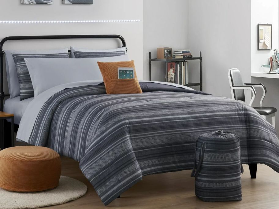 a queen bed made with a grey and black 12-Piece Bed in a Bag Set