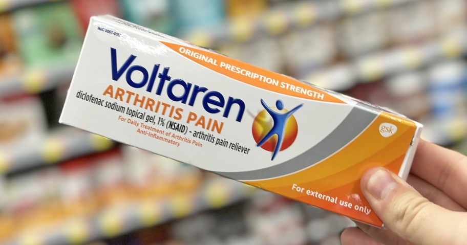 hand holding a white and orange box of Voltaren in store
