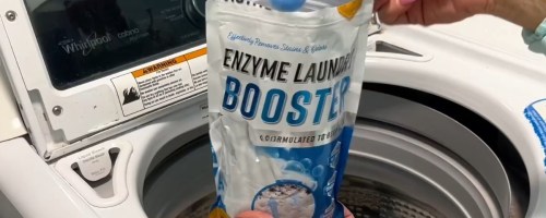 person holding a bag of Active Enzyme Laundry Booster Odor Remover 2 Lb. Bag and scooping some out into a washing machine