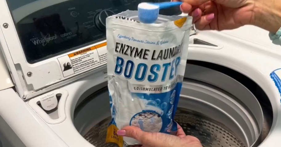 person holding a bag of Active Enzyme Laundry Booster Odor Remover 2 Lb. Bag and scooping some out into a washing machine