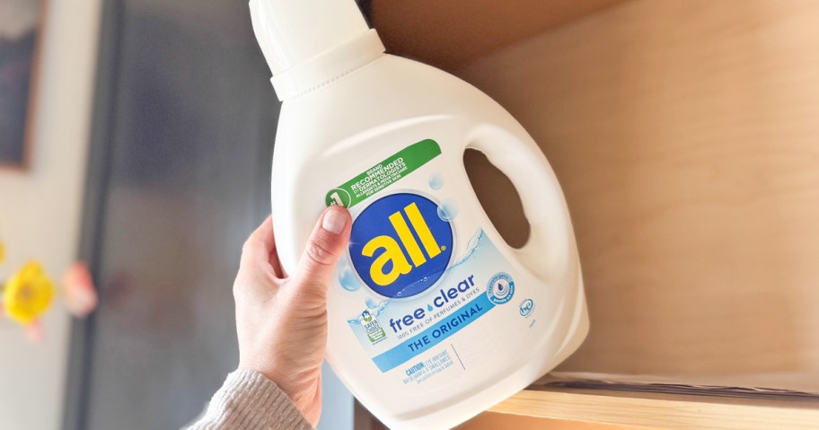 hand grabbing a bottle of all detergent from shelf