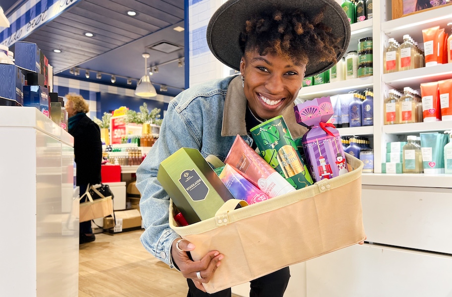 woman holding tub of bath and body works goodies