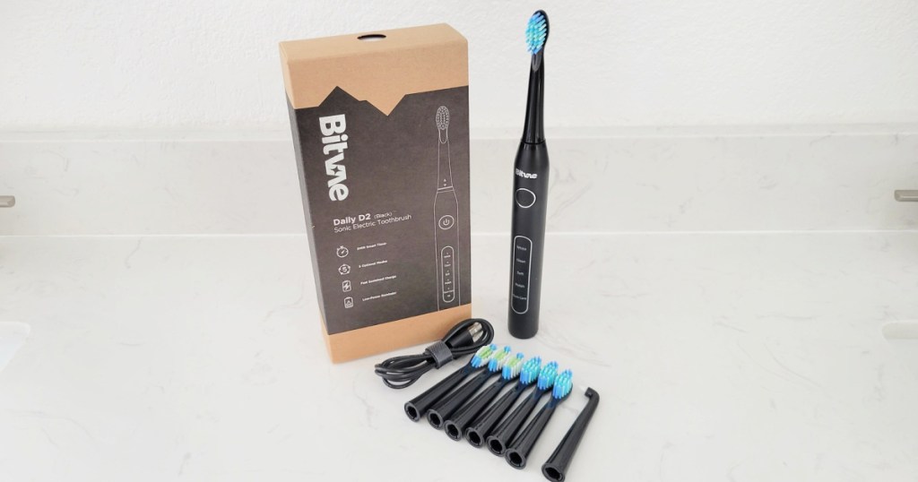 bitvae toothbrush, package and 8 brush heads on a counter