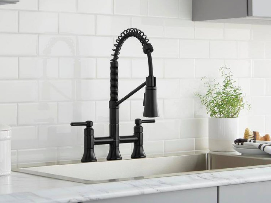 black kitchen faucet displayed on a gray kitchen sink