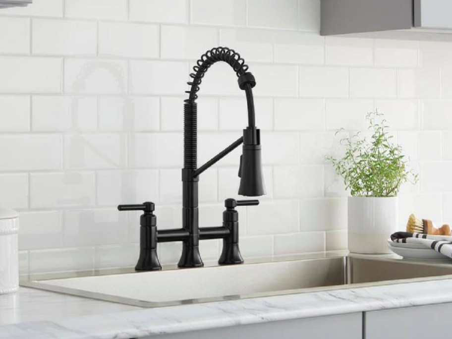black kitchen faucet displayed on a gray kitchen sink